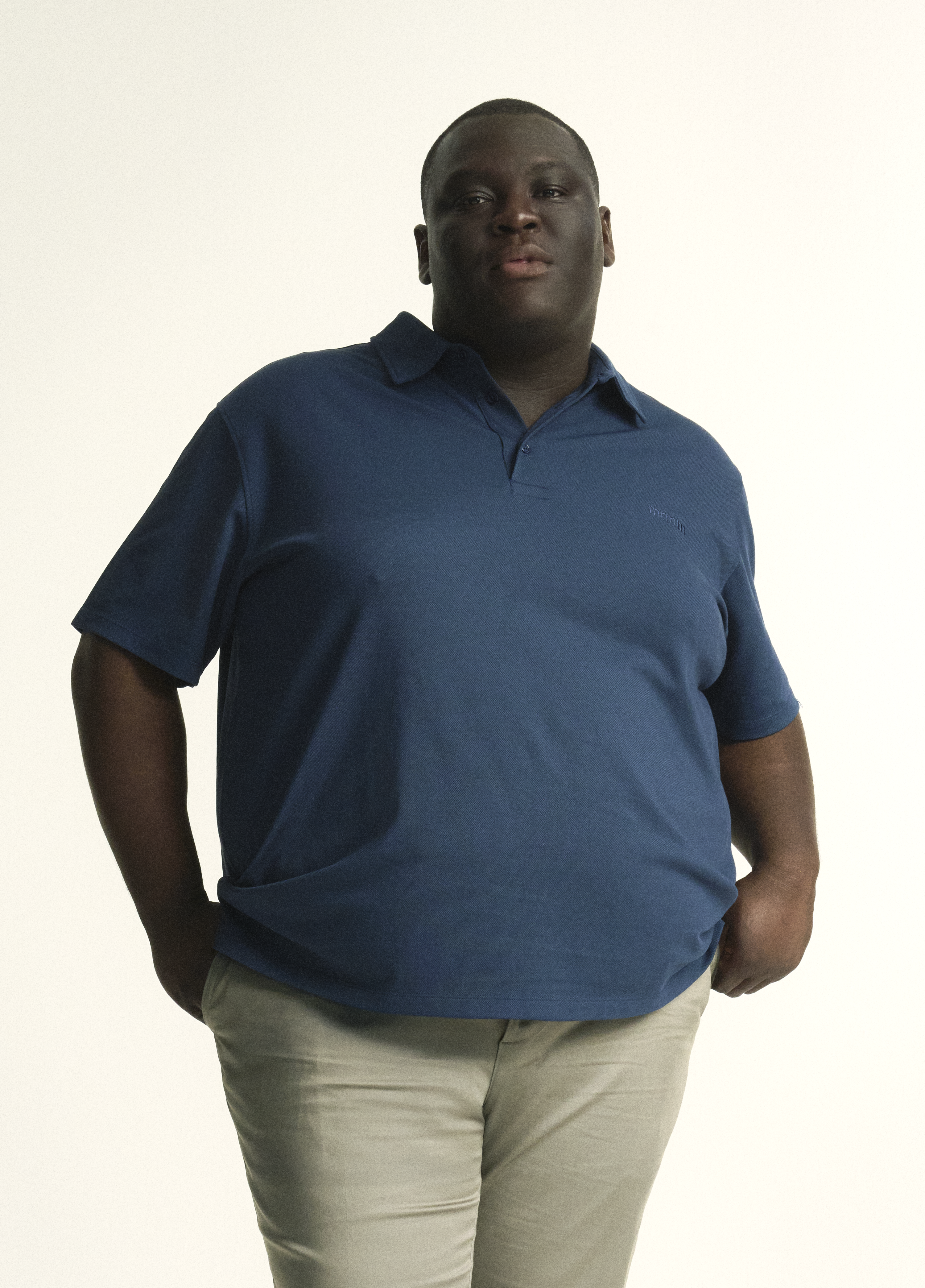 Model wearing plus size short sleeve mens breathable piqué polo in sizes XL-5XL, in dark blue, navy