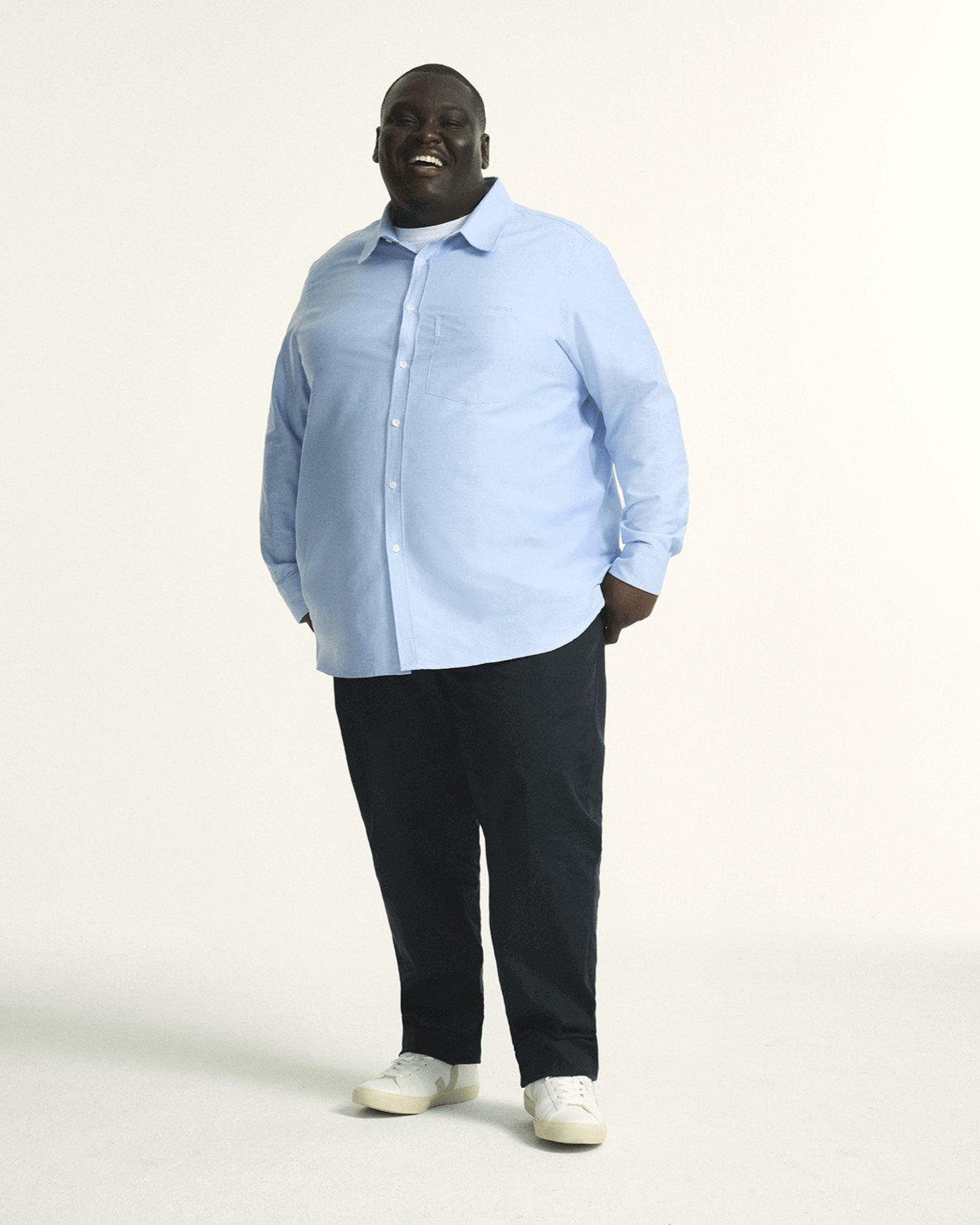 Model is wearing plus size menswear oxford shirt in Light blue. in size XL-5XL. Plus size regular fit navy menswear chino. Stretch chino for men in sizes XL–5XL (38–44) with comfort waistband for modern style.