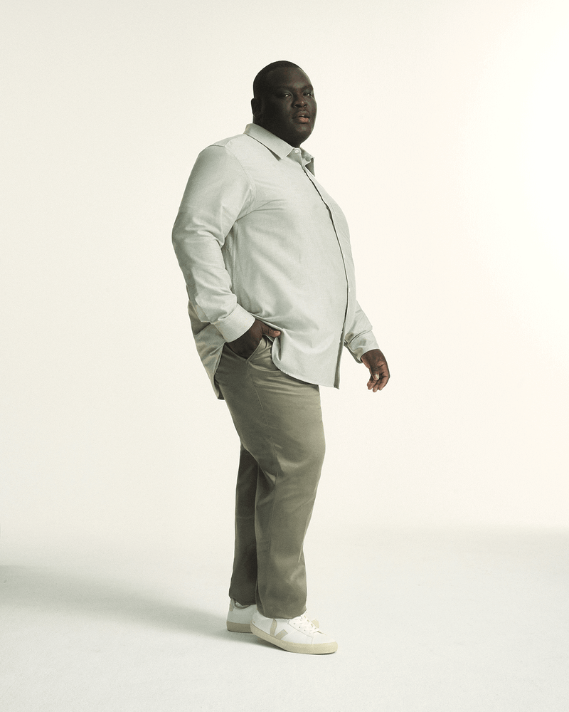 Model wearing The Tailored Oxford Shirt in Khaki, showcasing a classic fit designed for plus-size men and The Stretch Chino in Khaki, in regular fit, tailored for plus-size men with a comfortable elastic waistband