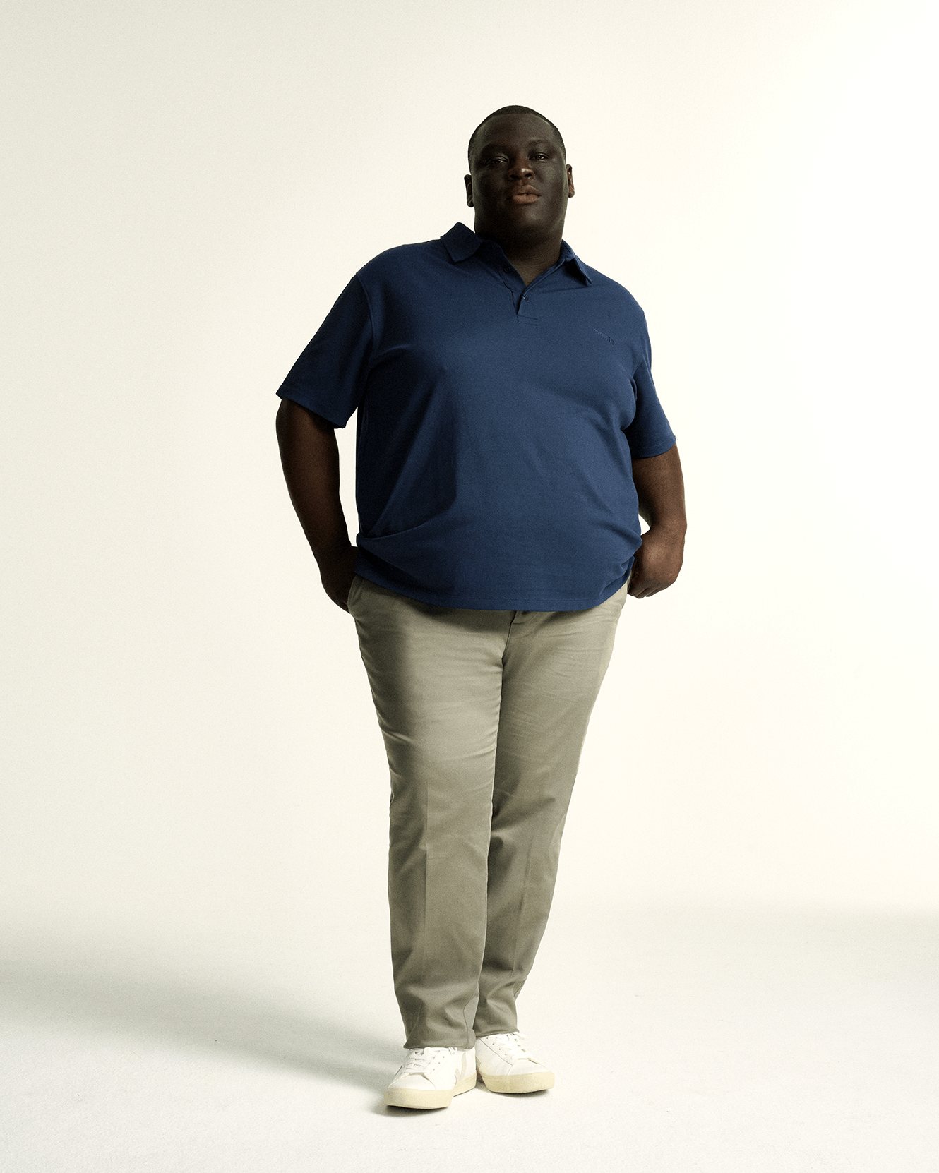 Model wearing plus size short sleeve mens breathable piqué polo in sizes XL-5XL, in dark blue, navy