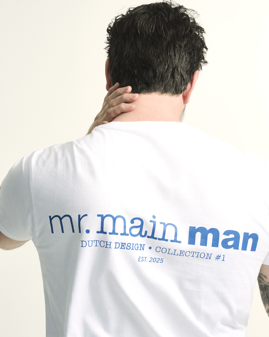 Model wearing the T-shirt in white with bright blue print, a minimalist design for plus-size men