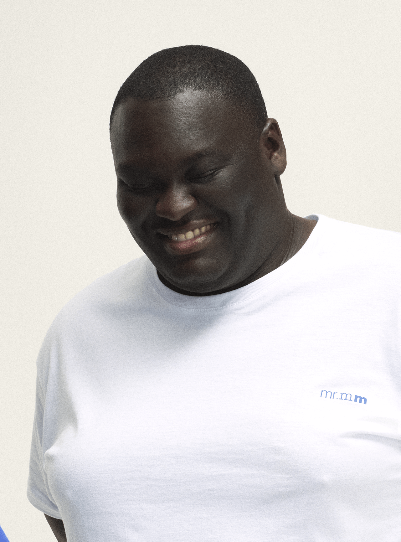 Model wearing the T-shirt in white with bright blue print, a minimalist design for plus-size men
