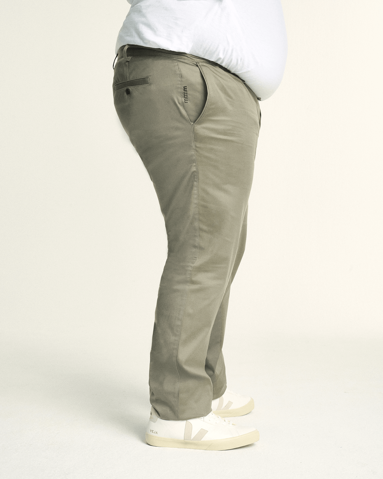 Side view of Model is wearing a plus size regular fit khaki green menswear chino. Stretch chino for men in sizes XL–5XL (38–44) with comfort waistband for modern style.