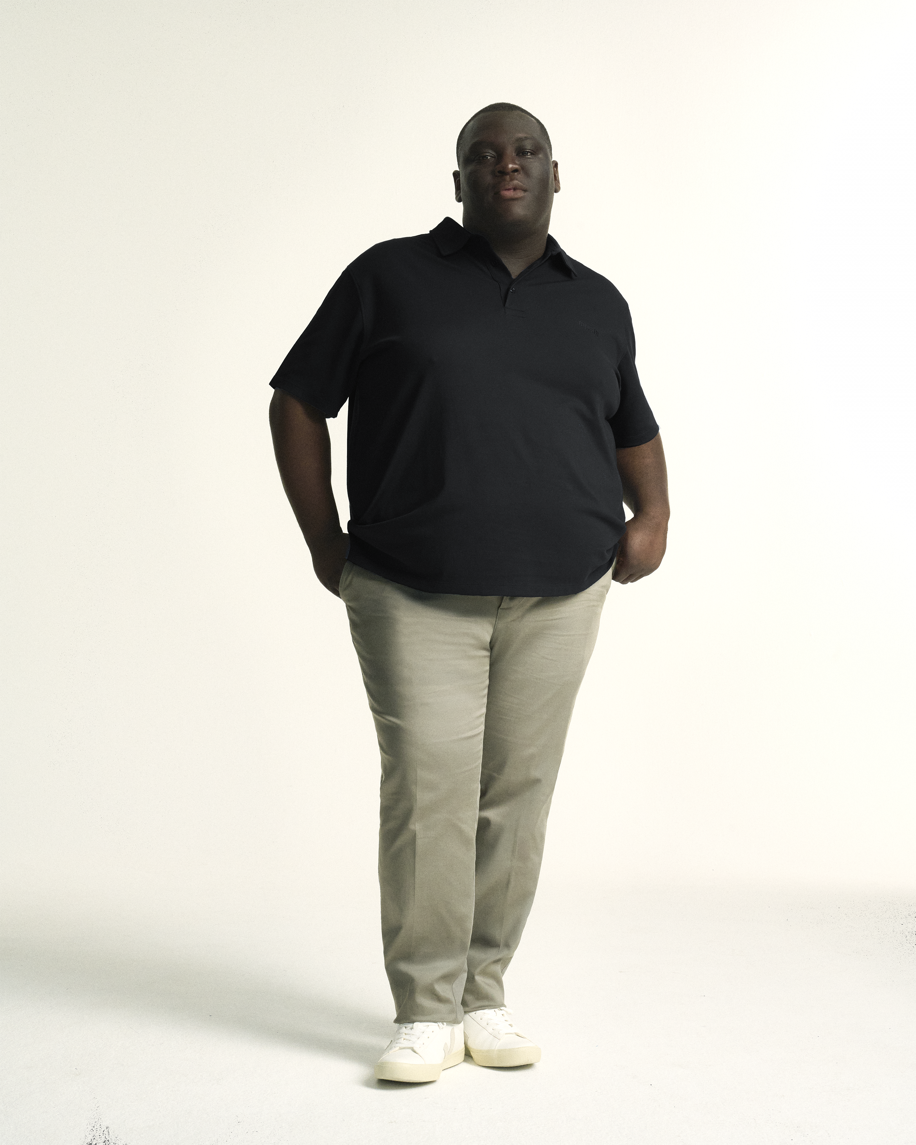 Model wearing plus size short sleeve mens breathable piqué polo in sizes XL-5XL, in black